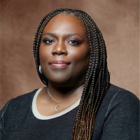 Dr. Karen T. Jackson, Ph.D. is a Black woman with long dark braids wearing a black shirt.