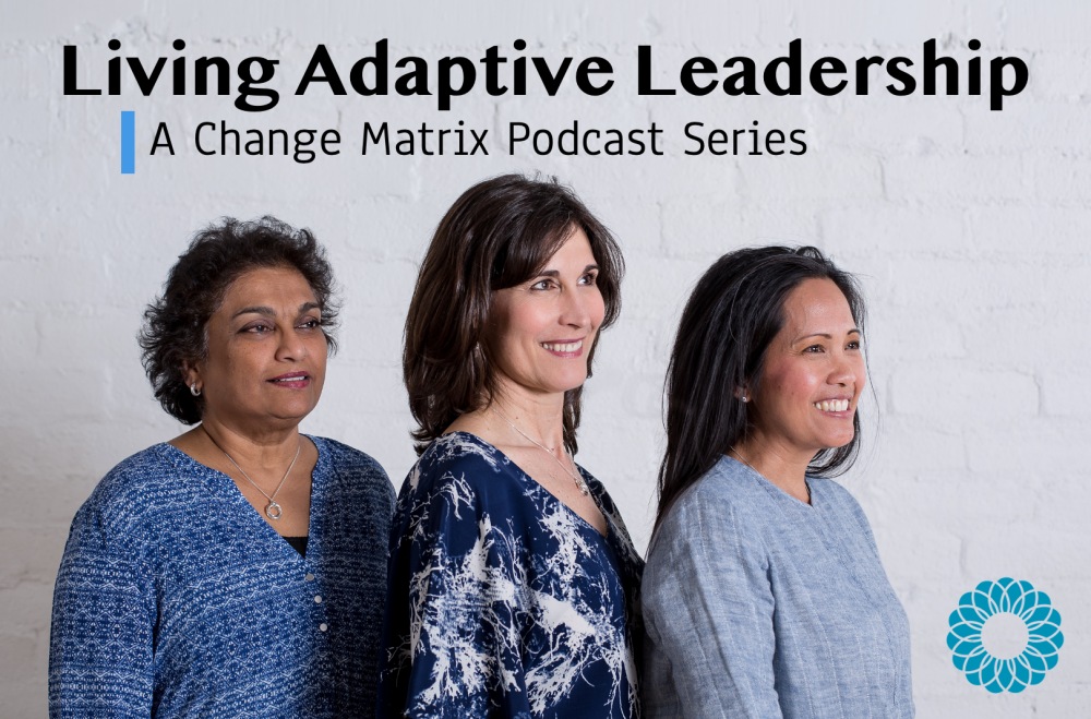 Living Adaptive Leadership: A Change Matrix Podcast cover image with Suganya Sockalingam, Elizabeth Waetzig, and Rachele Espiritu wearing blue shirts, facing to the right, and smiling in front of a white brick wall with the CM logo in the bottom right corner